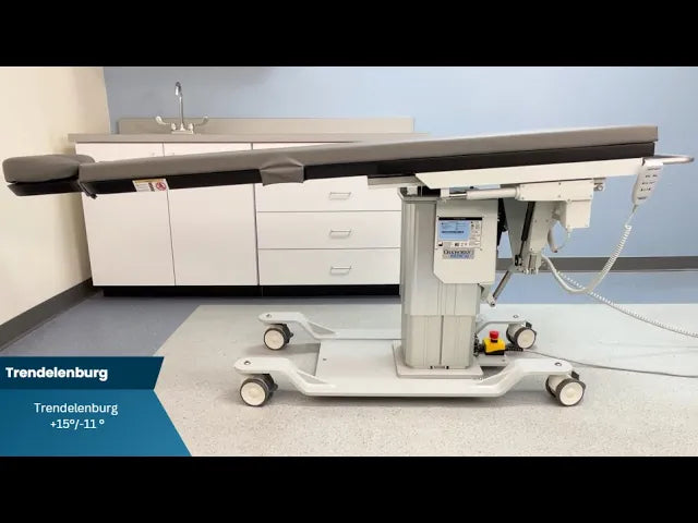 Medical examination table in a clinical setting with Trendelenburg positioning indicator.